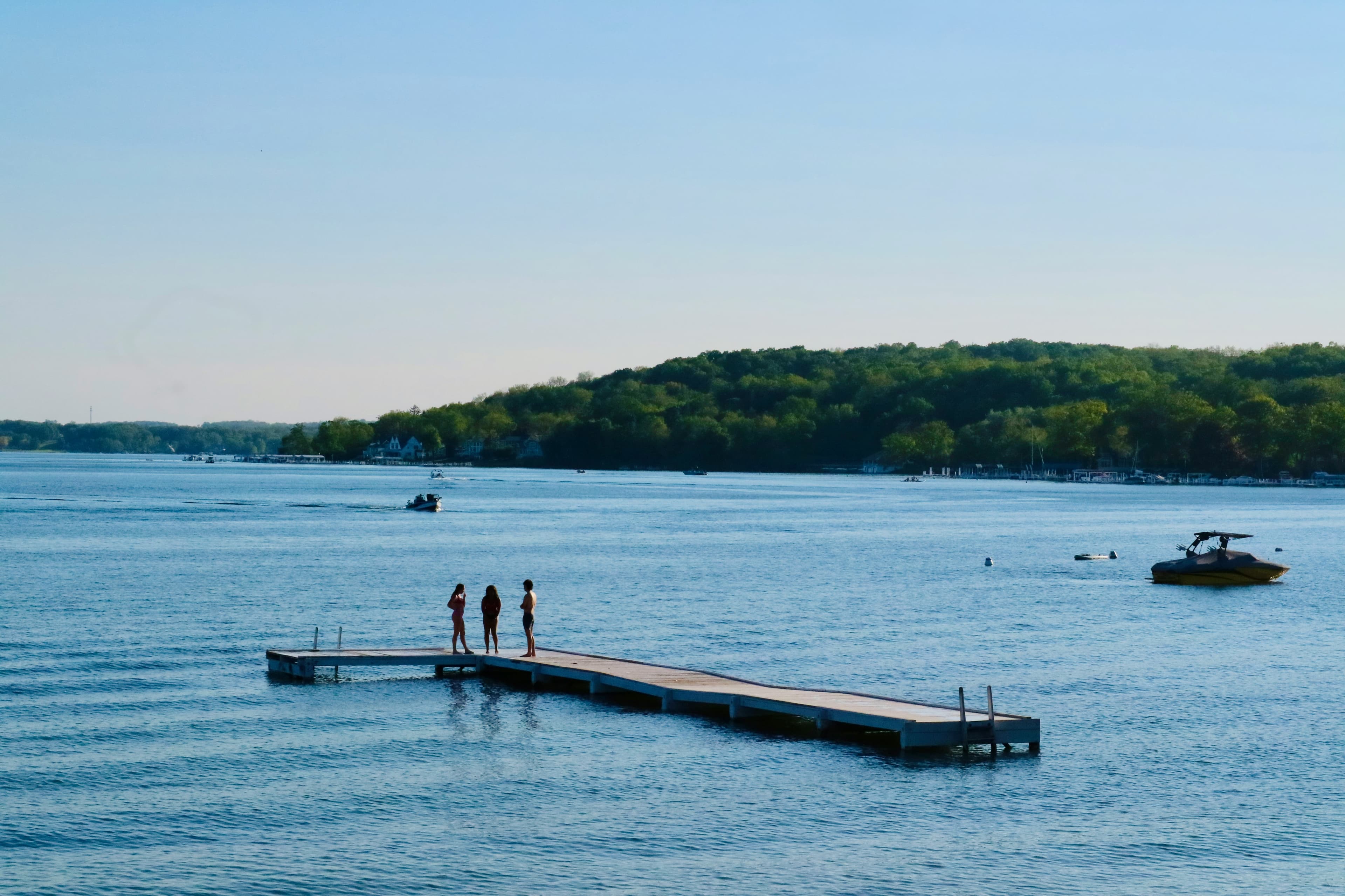 A dock on a lake with trees in the background